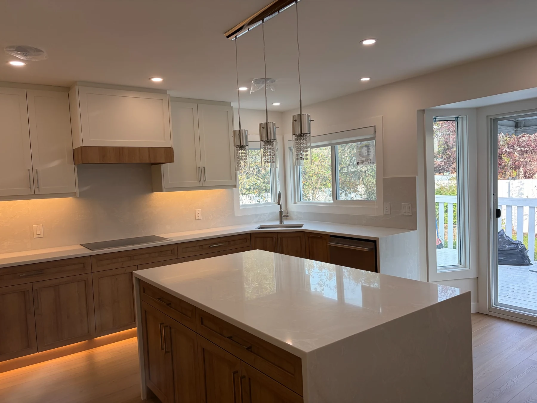 A kitchen cleaned by Shiny Rock Janitorial, with wood cabinets and white countertops